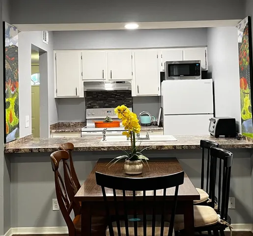 a kitchen with stainless steel appliances a sink a table and chairs