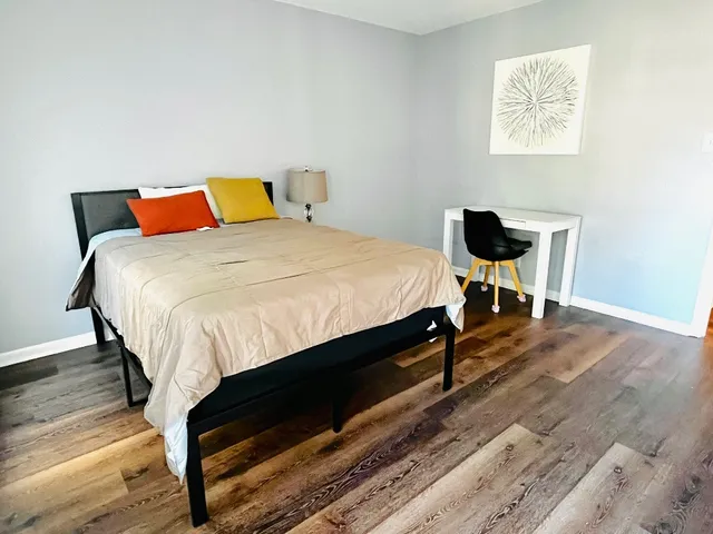 a bedroom with a bed and wooden floor