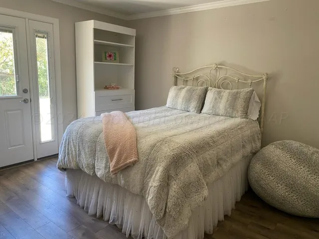 a bedroom with a bed and wooden floor