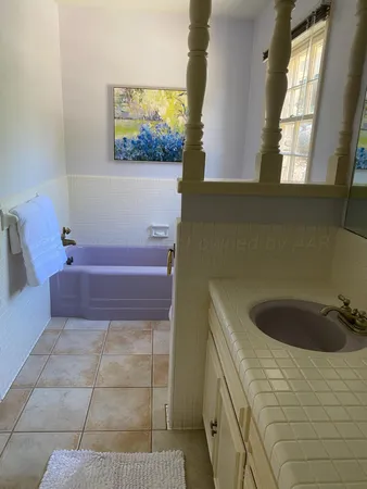 a bathroom with a bathtub sink and window