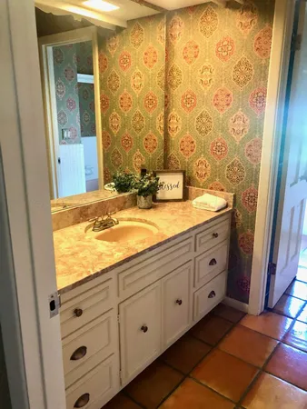 a bathroom with a granite countertop sink and a mirror
