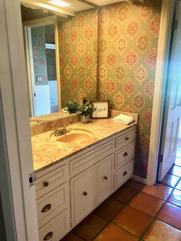 a bathroom with a granite countertop sink and a mirror