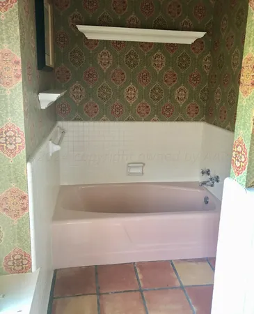 a bath tub sitting in a bathroom next to a sink