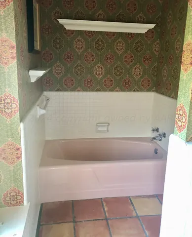 a bath tub sitting in a bathroom next to a sink