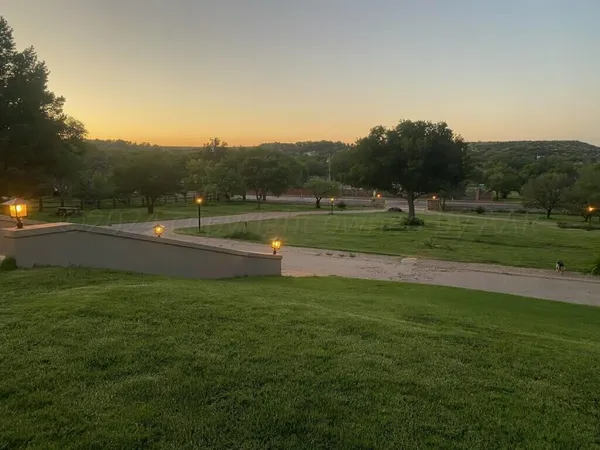 a yard with lots of green space and trees