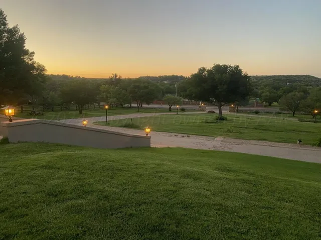 a yard with lots of green space and trees