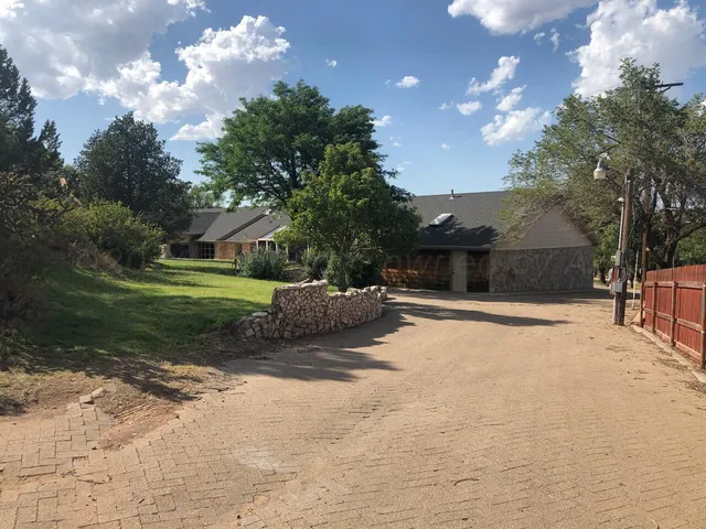 a view of a house with backyard and sitting area
