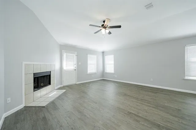 a view of empty room with wooden floor fireplace and windows
