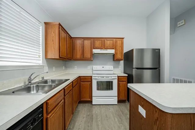 a kitchen with stainless steel appliances granite countertop a sink stove and refrigerator