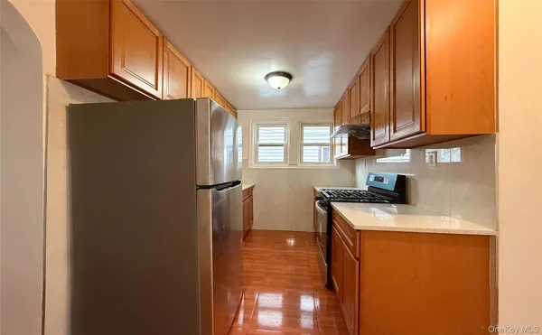 a kitchen with stainless steel appliances granite countertop a refrigerator a sink and a stove