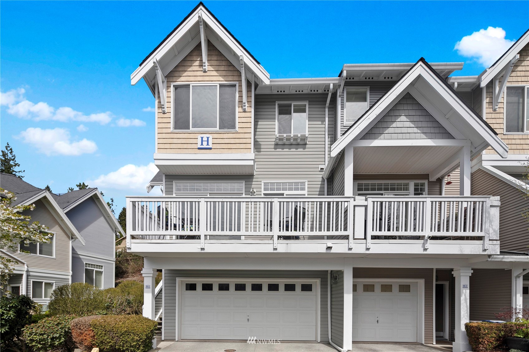 23120 Southeast Black Nugget Road, Unit H1 Issaquah, WA 98029 - Photo 2 of 27 a front view of a house with a yard