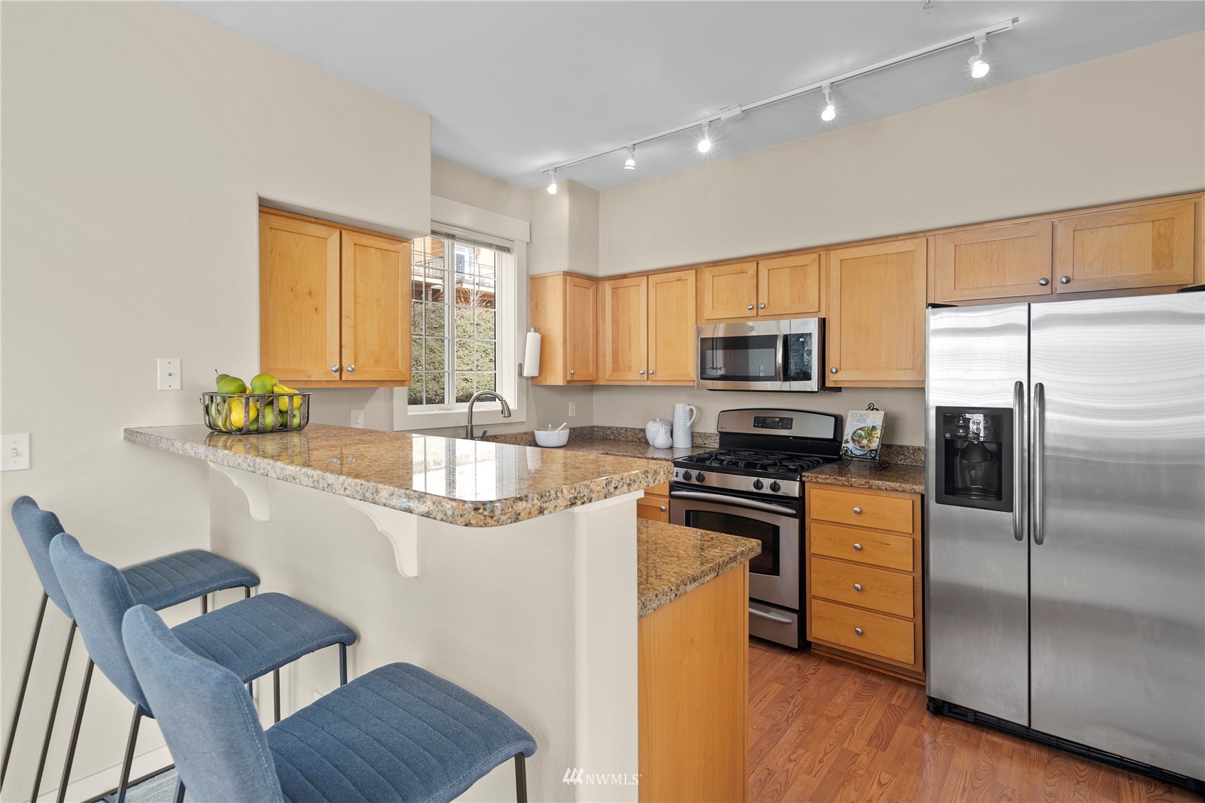 23120 Southeast Black Nugget Road, Unit H1 Issaquah, WA 98029 - Photo 9 of 27 a kitchen with granite countertop a sink appliances and cabinets