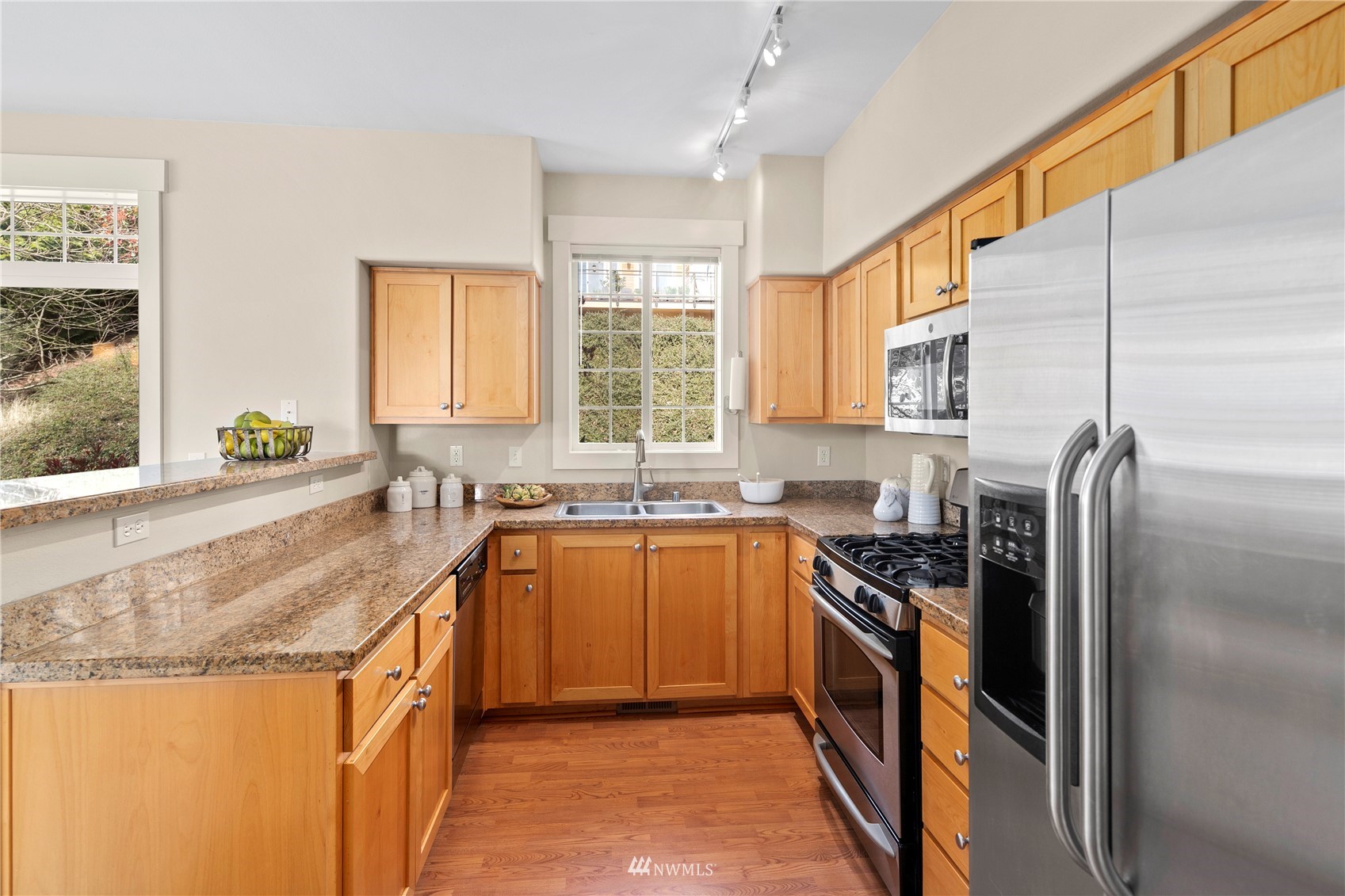23120 Southeast Black Nugget Road, Unit H1 Issaquah, WA 98029 - Photo 10 of 27 a kitchen with stainless steel appliances granite countertop refrigerator a sink a stove a washer dryer and a refrigerator