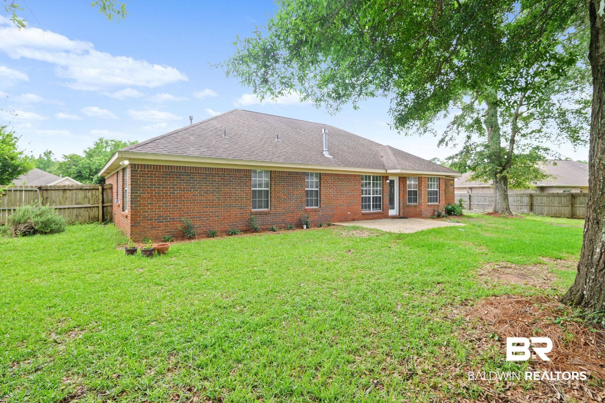 9422 Labrador Run South Mobile, AL 36695 - Photo 34 of 36 Expansive green lawn surrounds a brick exterior home with a grey shingle roof