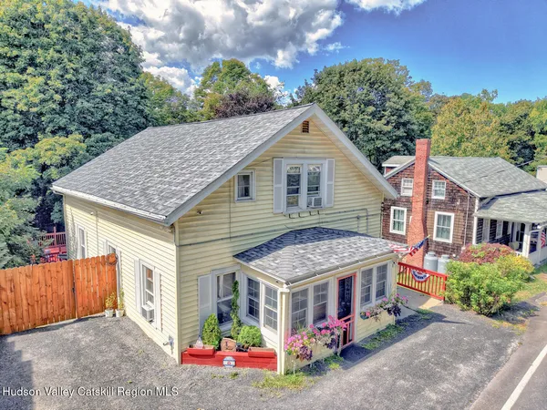 a view of a house with a yard and potted plants