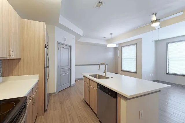 a kitchen with a sink refrigerator and cabinets