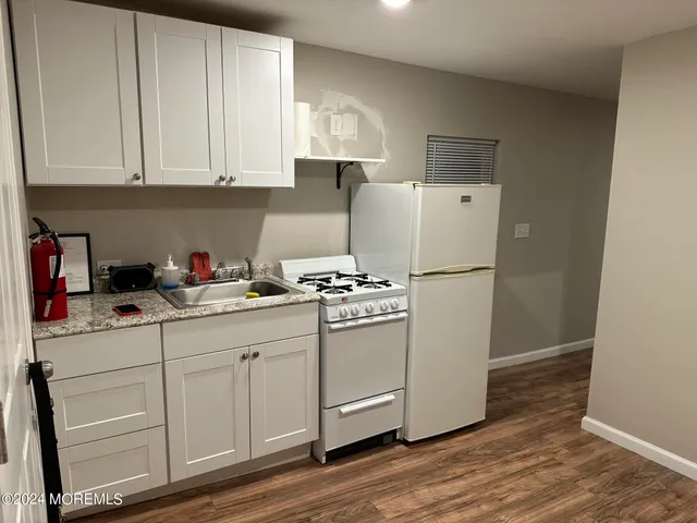 a kitchen with stainless steel appliances white cabinets and a refrigerator