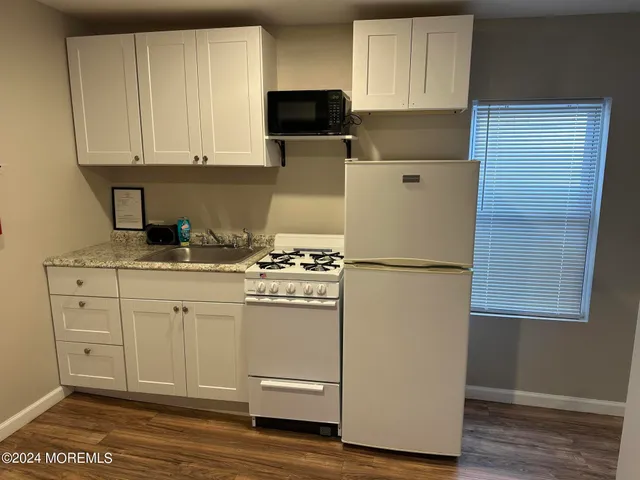 a kitchen with appliances a sink and cabinets