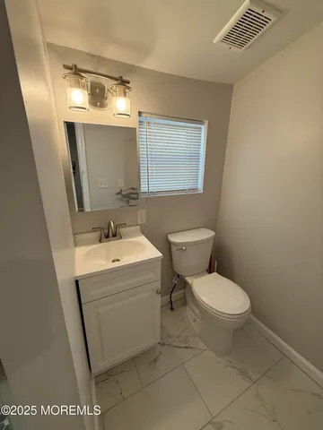 a bathroom with a sink toilet and mirror