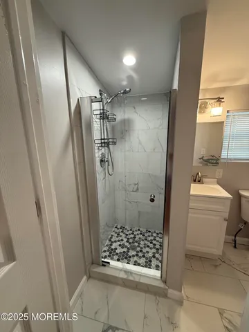 a bathroom with a glass door shower a toilet and a sink