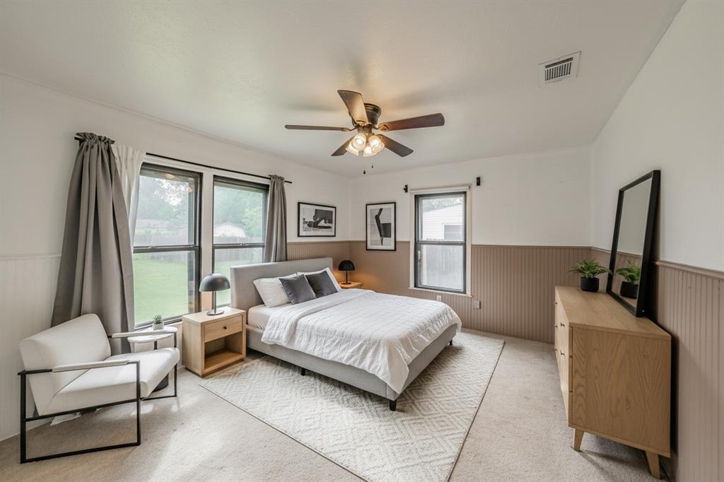 1802 Keneipp Road Carrollton, TX 75006 - Photo 12 of 22 This spacious room features a ceiling fan, windows offering views of the outdoors, and wall paneling