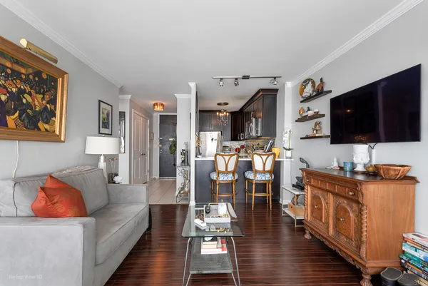 a living room with furniture kitchen view and a flat screen tv