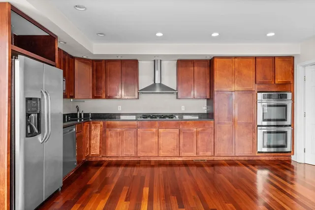 a kitchen with stainless steel appliances granite countertop a refrigerator and a sink