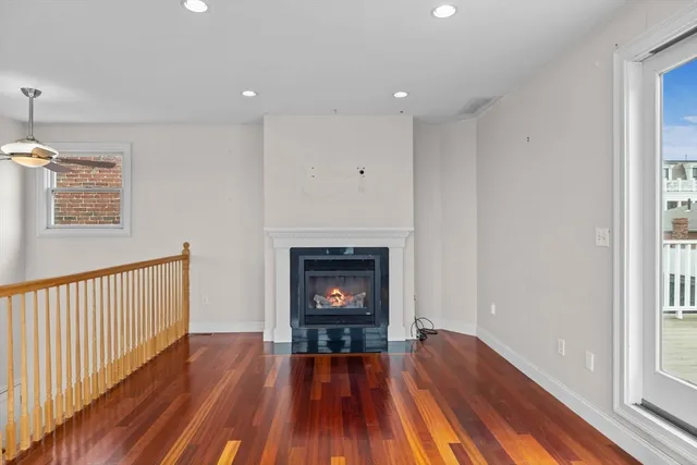 a view of a livingroom with wooden floor and a fireplace
