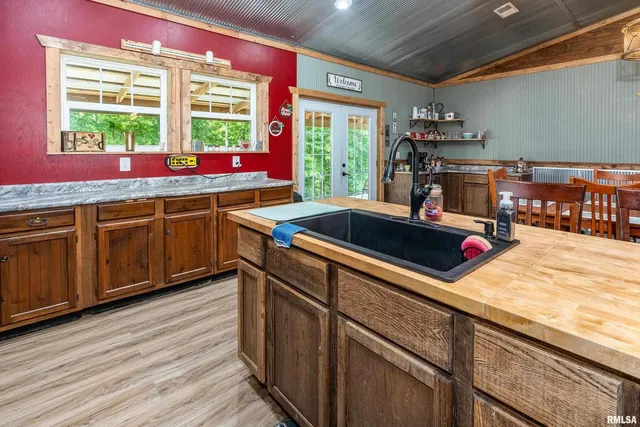a kitchen with lots of counter top space a sink appliances and dining room