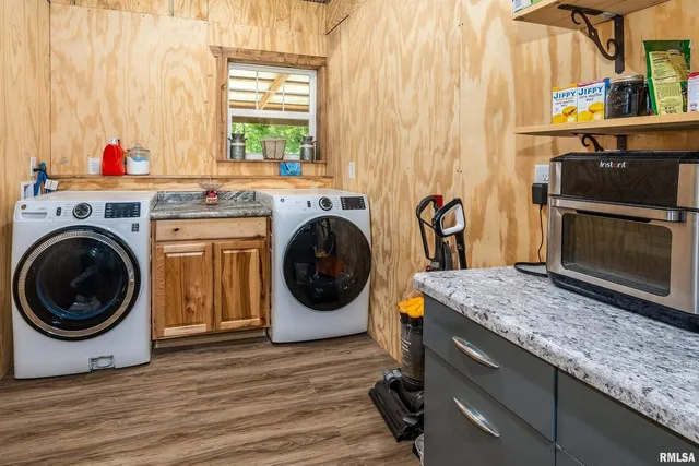 a kitchen with stainless steel appliances granite countertop a refrigerator and a wooden floor