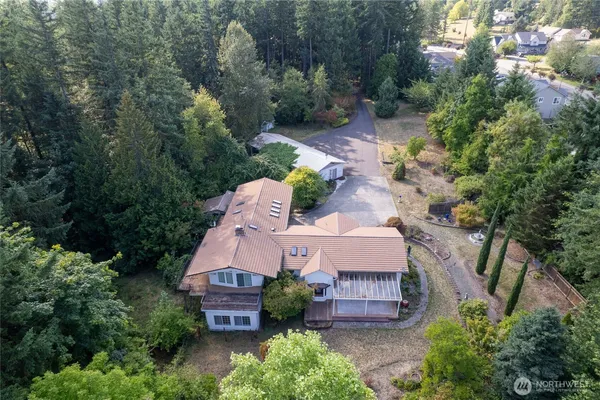an aerial view of a house with a yard and large trees