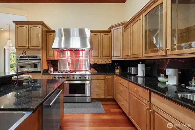 a kitchen with stainless steel appliances granite countertop a stove sink and cabinets