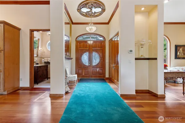 a view of a hallway with wooden floor and a living room