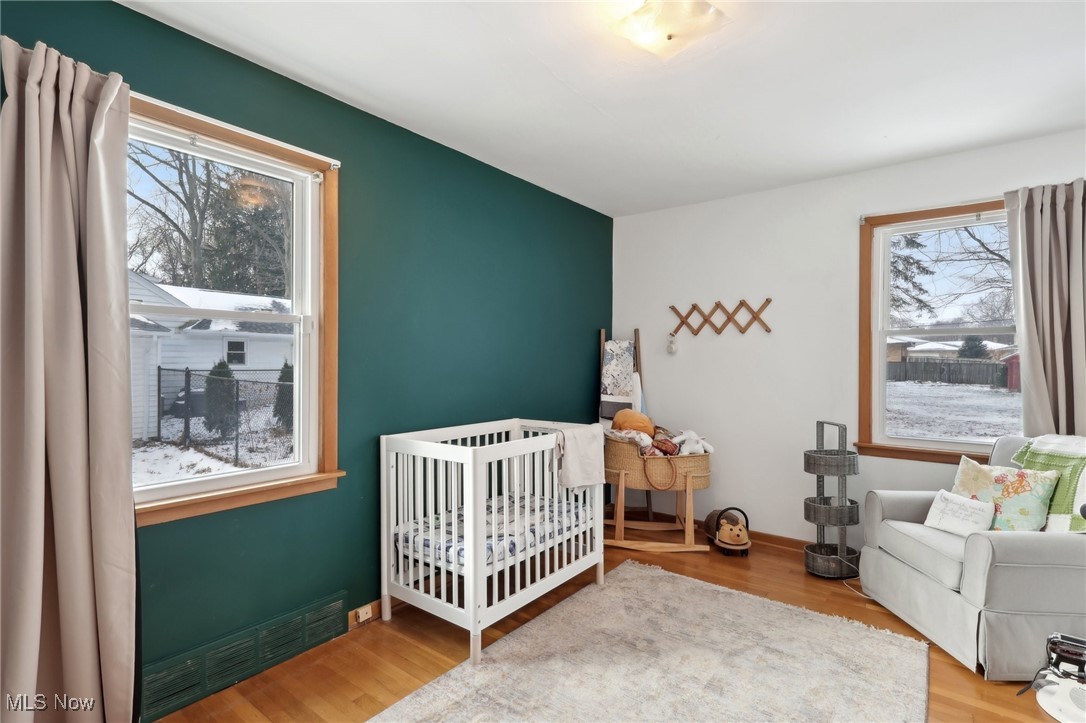 6086 Crossview Road Independence, OH 44131 - Photo 24 of 44 Bedroom with hardwood / wood-style floors, a crib, a baseboard radiator, and multiple windows
