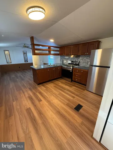 a room with kitchen island a stove and a wooden floors