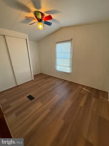a view of an empty room and window with a ceiling fan