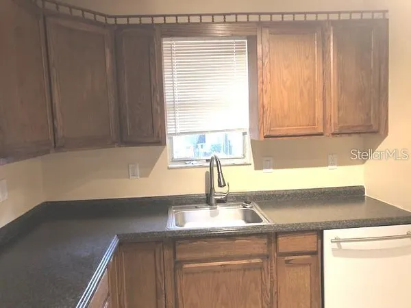 a kitchen with a sink cabinets and a window