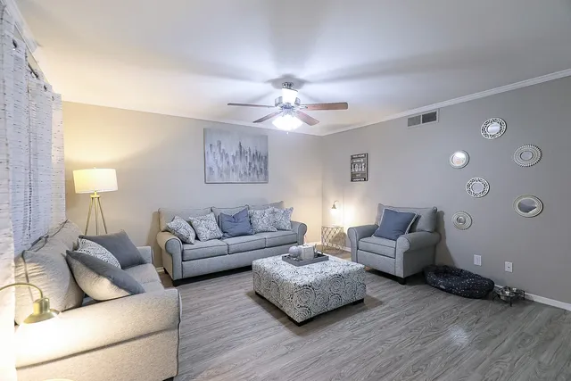 a living room with furniture and a wooden floor