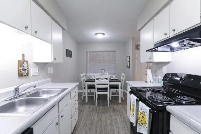 a kitchen with stainless steel appliances granite countertop a sink stove refrigerator and cabinets