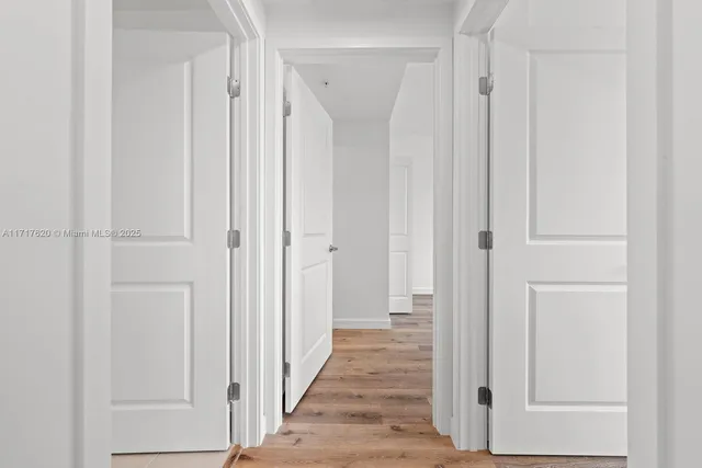 a view of a hallway with wooden floor