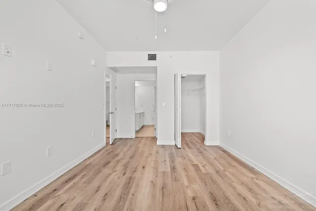 a view of a big room with wooden floor and windows