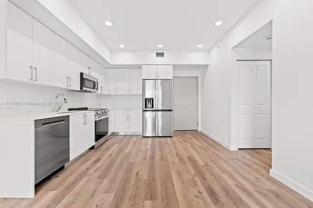 a kitchen with wooden floors and white appliances