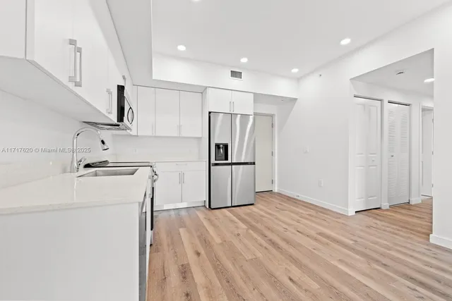 a view of kitchen with wooden floor and electronic appliances