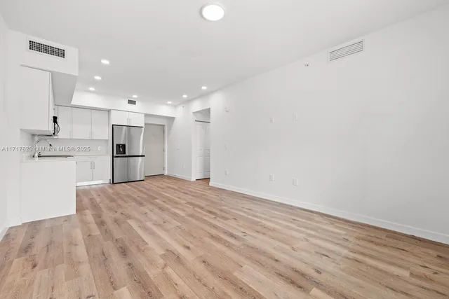a view of large kitchen with a refrigerator and a sink