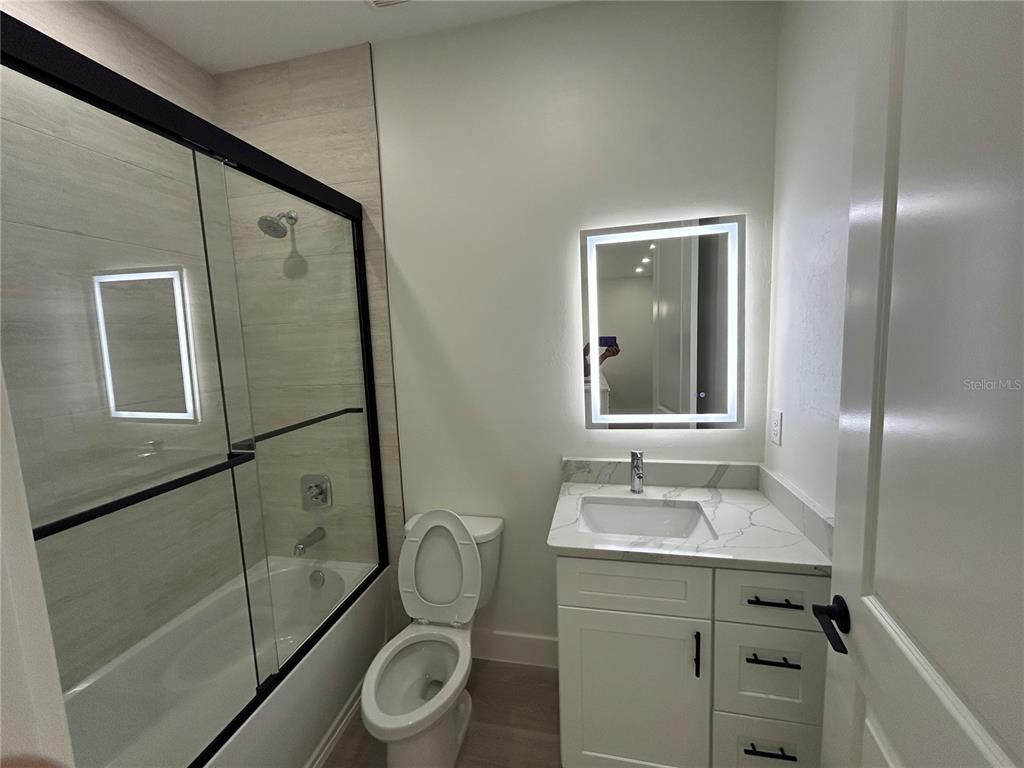 7361 South Plum Tree Punta Gorda, FL 33955 - Photo 6 of 14 a bathroom with a granite countertop sink toilet a mirror and shower