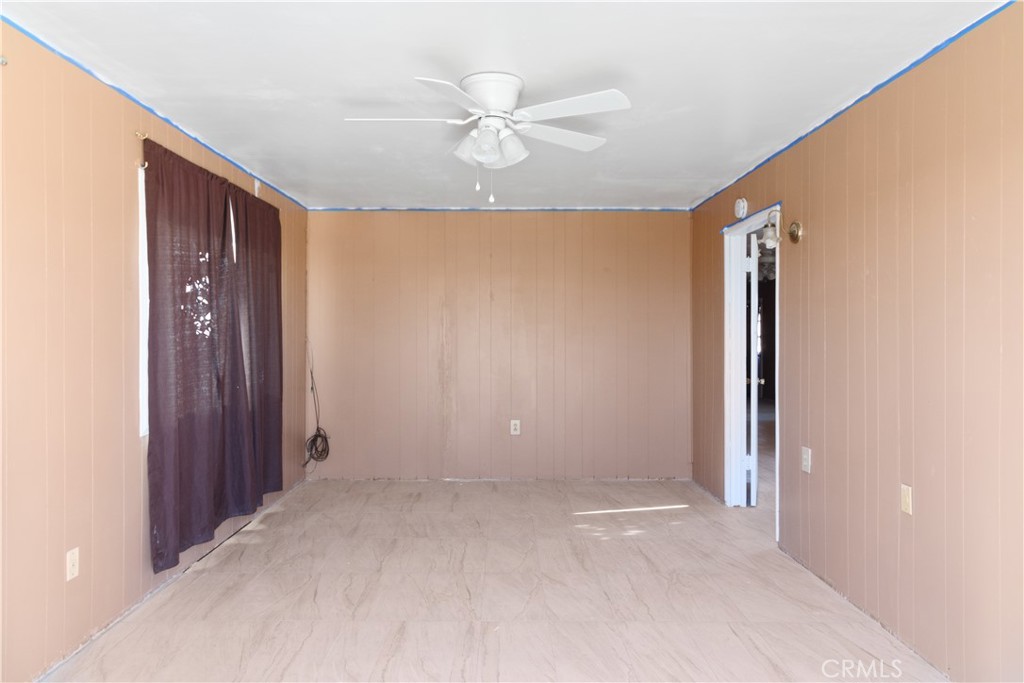 26850 Hampton Road Boron, CA 93516 - Photo 7 of 9 an empty room with a ceiling fan and a window