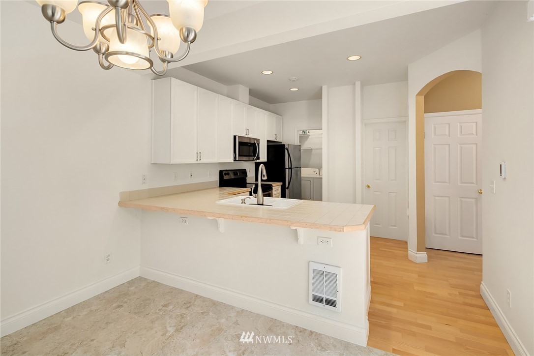 10909 Avondale Road Northeast, Unit F122 Redmond, WA 98052 - Photo 13 of 24 a view of kitchen with cabinets and wooden floor