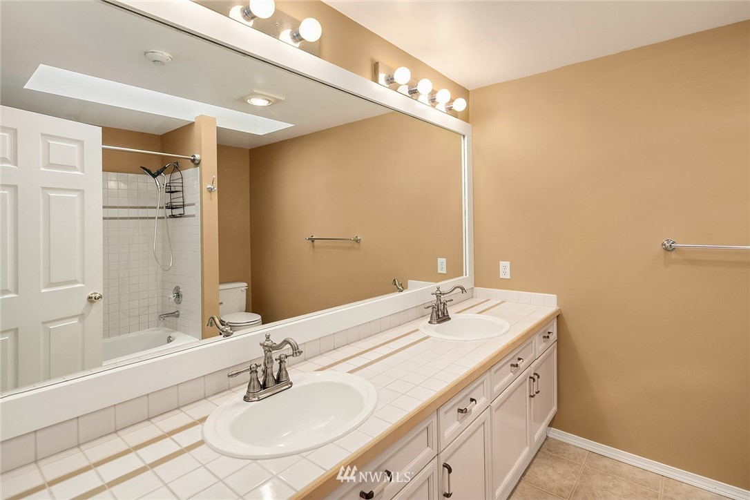 10909 Avondale Road Northeast, Unit F122 Redmond, WA 98052 - Photo 19 of 24 a bathroom with a sink and a mirror