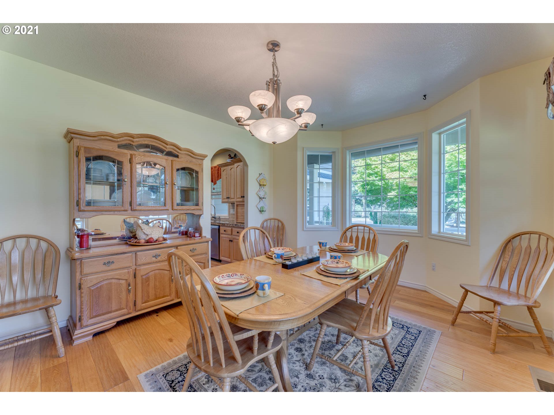43126 Southeast Music Camp Road Sandy, OR 97055 - Photo 11 of 32 a dining room with wooden floor a chandelier a wooden table and chairs