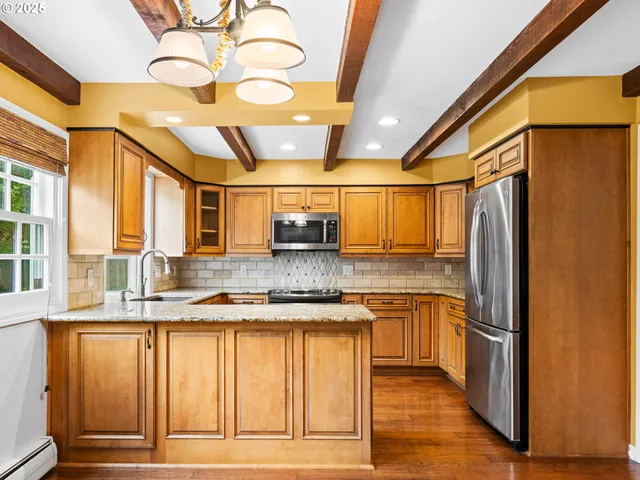 a kitchen with stainless steel appliances granite countertop a refrigerator and a sink